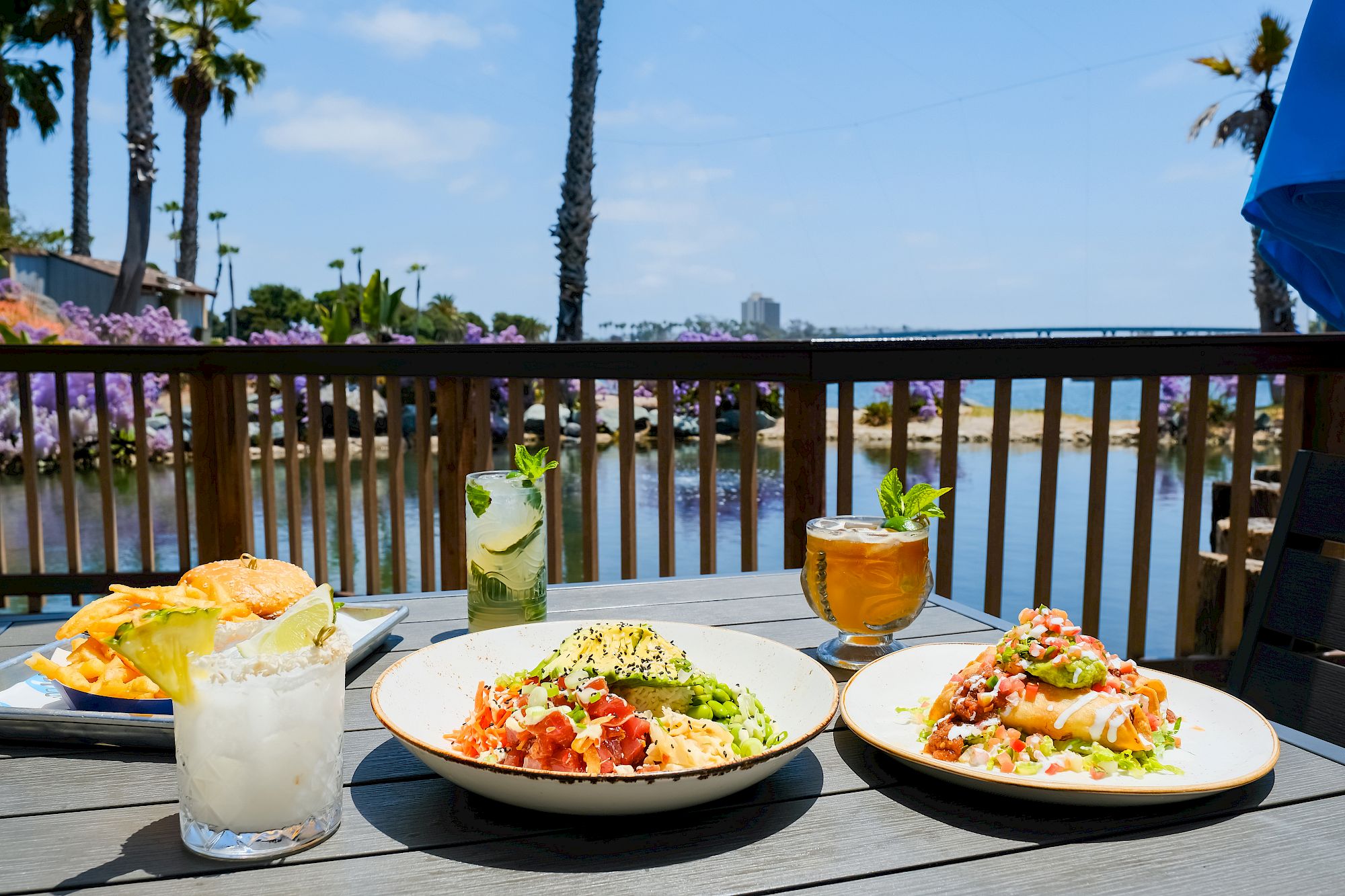 Food and cocktails on a waterfront table at Barefoot Bar & Grill, overlooking the lagoon and Mission Bay