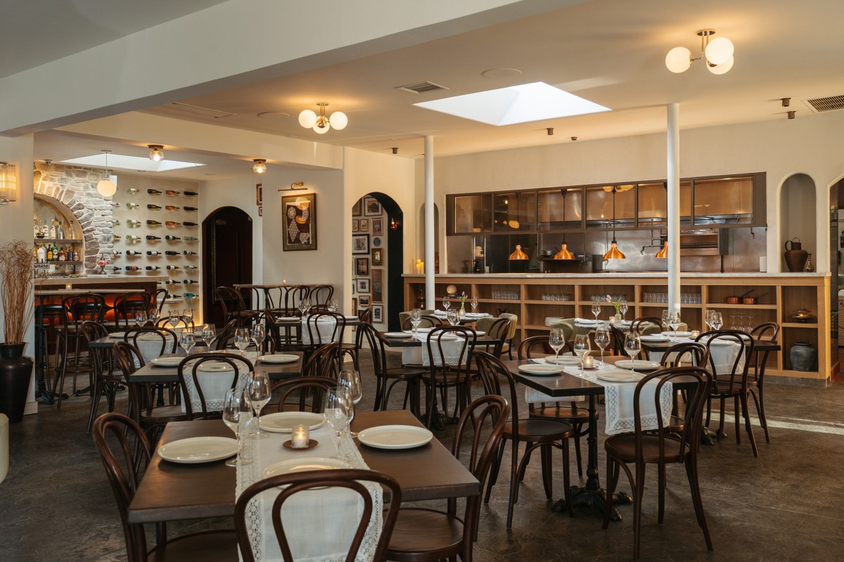 Bosforo dining room in Normal Heights, with white table linens, wooden chairs and warm lighting.