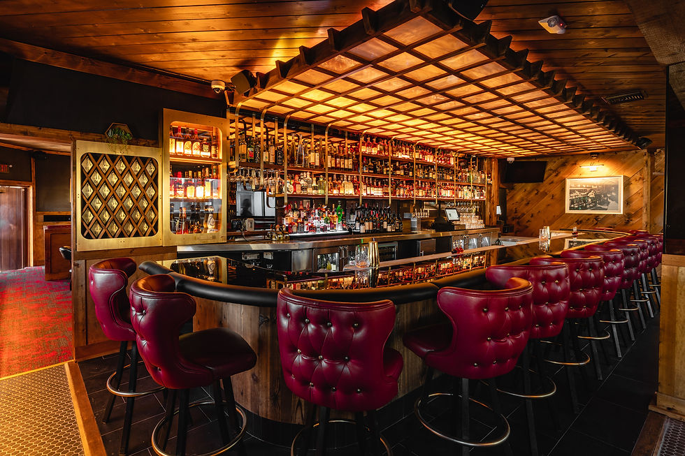 Warm wood bar and burgundy leather stools at Moe’s Mission Beach steakhouse.